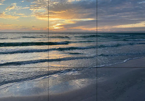 Sunset casting vibrant colors over ocean waves on sandy beach for stunning beach photos.