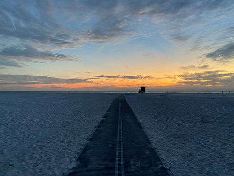 Wooden boardwalk leads to horizon, perfect for stunning beach photos with iPhone.